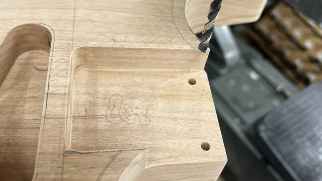 ボール盤でギターボディのネックプレート用の穴をあけたところ