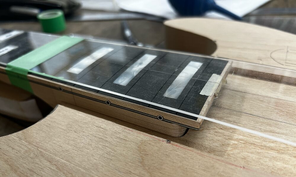 5弦ベースのボディにネックを合わせてはまるかを確認しておりるところ