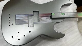 メタリックグレイカラーで塗装した5弦ベースのボディトップ