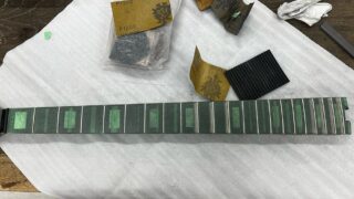 5弦ベースのフレットをサンドペーパーで磨いているところ