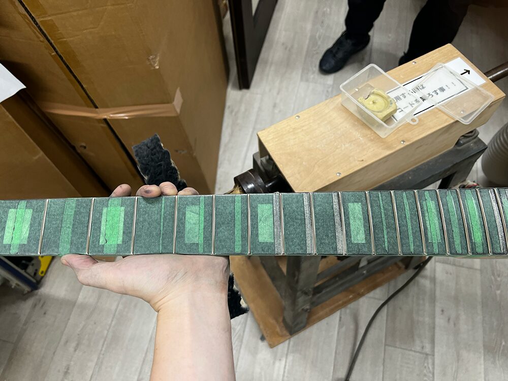 5弦ベースのフレットにバフがけをしているところ