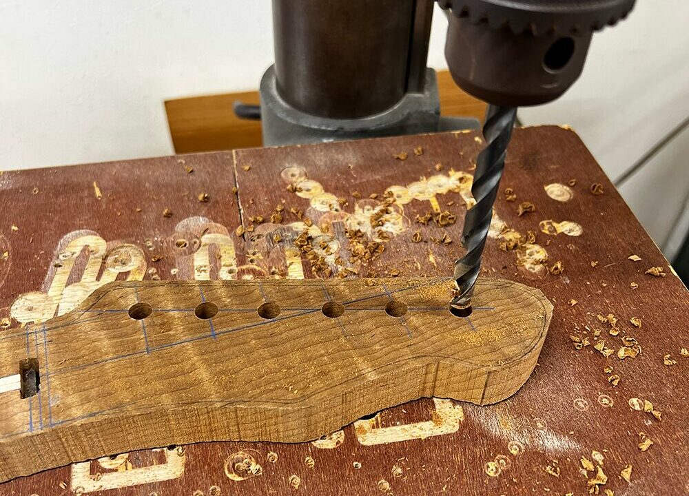 ギターのヘッドにボール盤でペグ穴を開けているところ