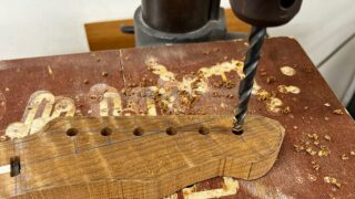 ギターのヘッドにボール盤でペグ穴を開けているところ