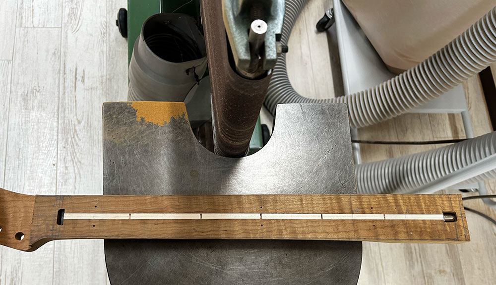 粗加工をした状態のギターのネックのサイドをエコノミーサンダーで削った状態