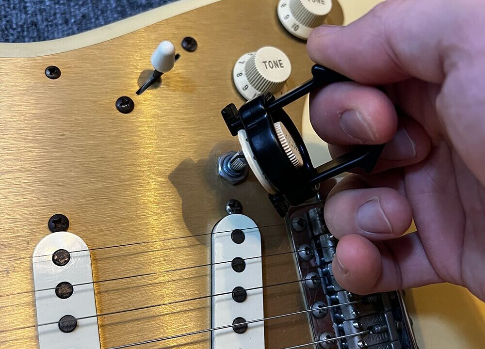 ギターのコントロールノブ取り外しツール・ノブプラーでストラトのノブを取り外しているところ