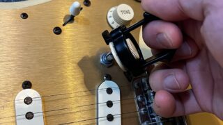 ギターのコントロールノブ取り外しツール・ノブプラーでストラトのノブを取り外しているところ