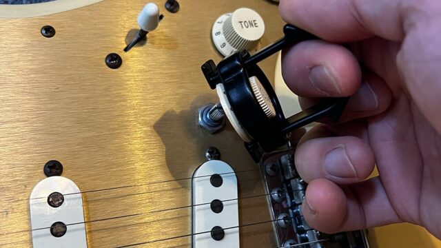 ギターのコントロールノブ取り外しツール・ノブプラーでストラトのノブを取り外しているところ