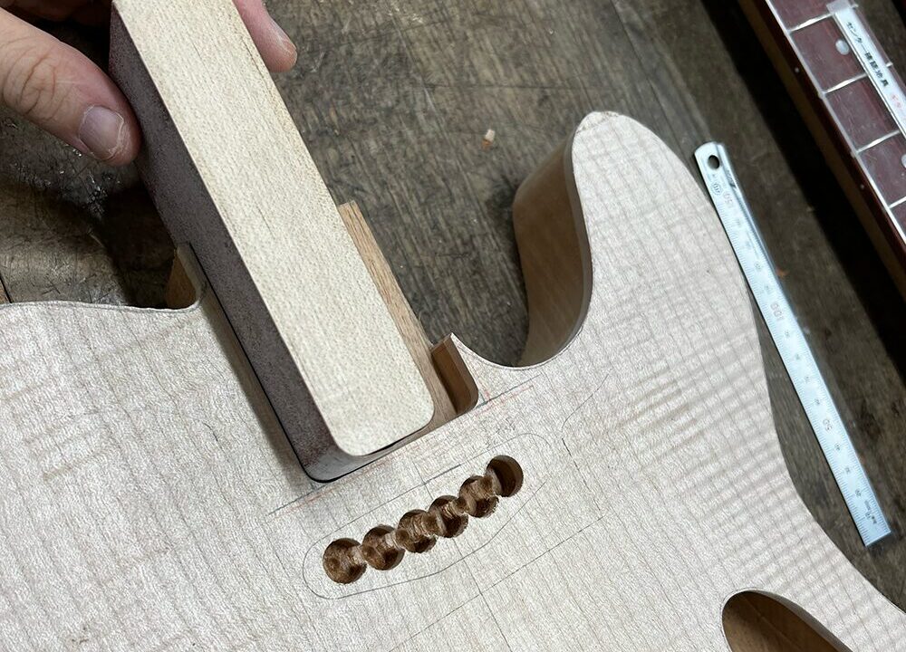 ギターのボディのネックポケットの内側をサンドペーパーで成形