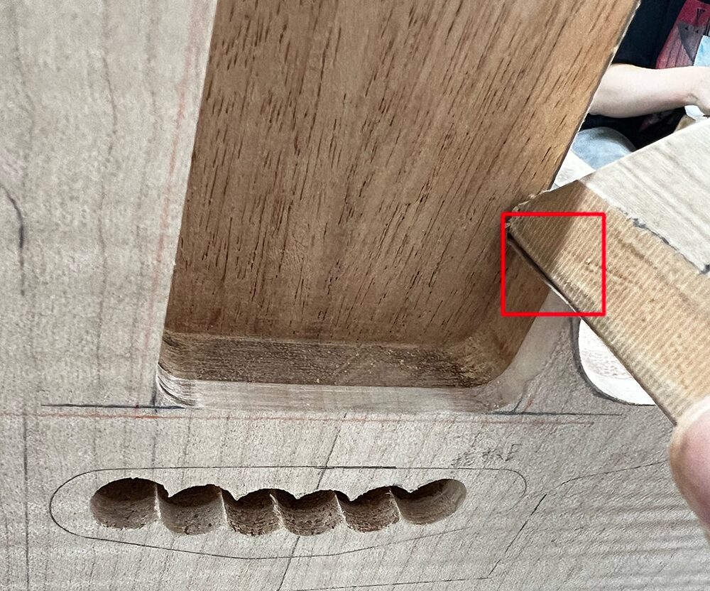 ギターボディのネックポケットと外周の境目を#150のサンドペーパーで磨いているところ