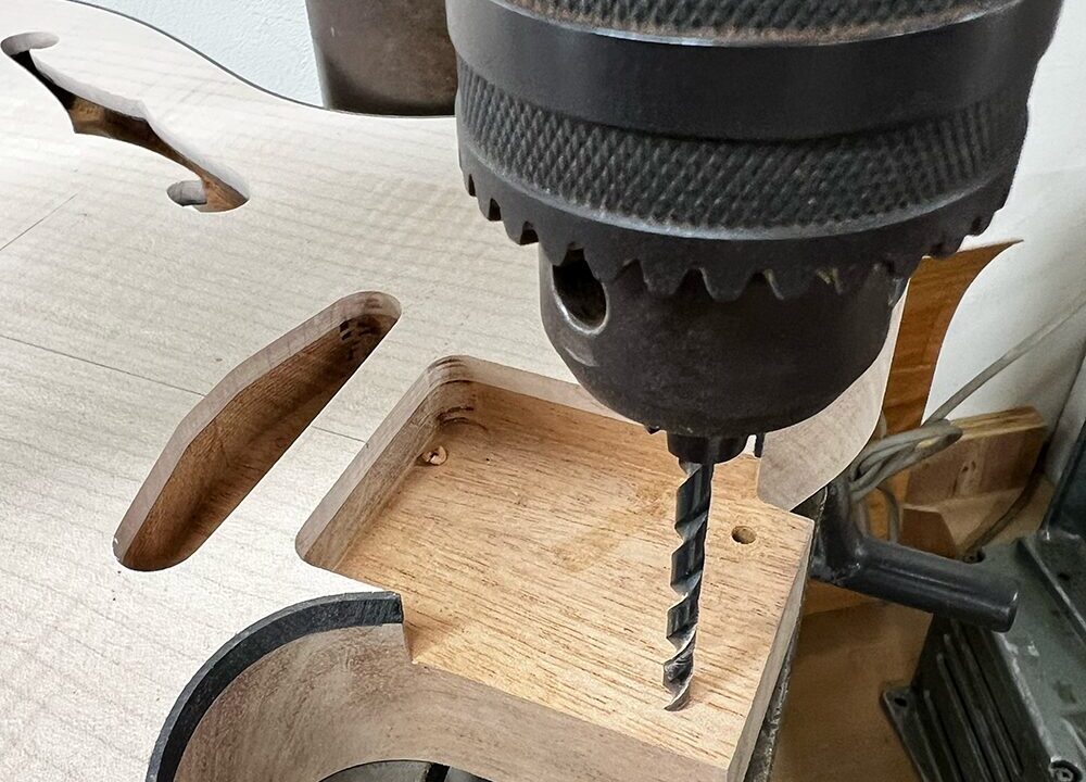 ボール盤でネックジョイントのビス穴を開けているところ