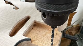 ボール盤でネックジョイントのビス穴を開けているところ