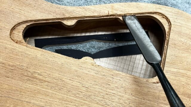 ギターボディのバックパネル落とし込み仕上げノミで削っているところ