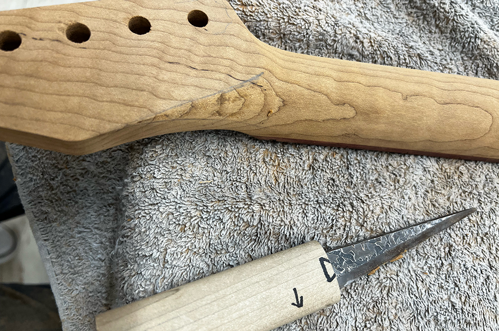 ローステッドフレイムメイプルネックのボリュートを小刀で成形