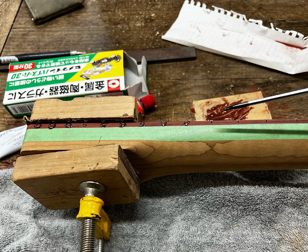 サティーネ指板のフレットサイドをエポキシで埋めているところ