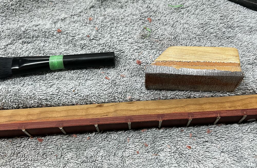 サティーネ指板のサイドを#320のサンドペーパーで磨いているところ