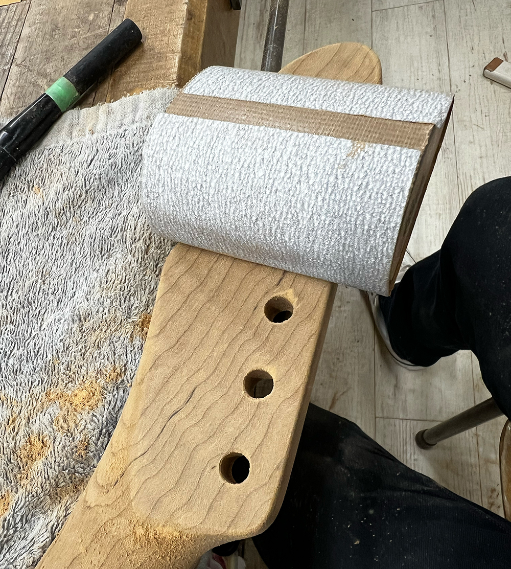 ギターのフレイムメイプルネックのヘッド裏を#320のサンドペーパーで磨いているところ