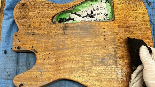 シンラインタイプのギターボディに塗ったウッドフィラーを拭いているところ