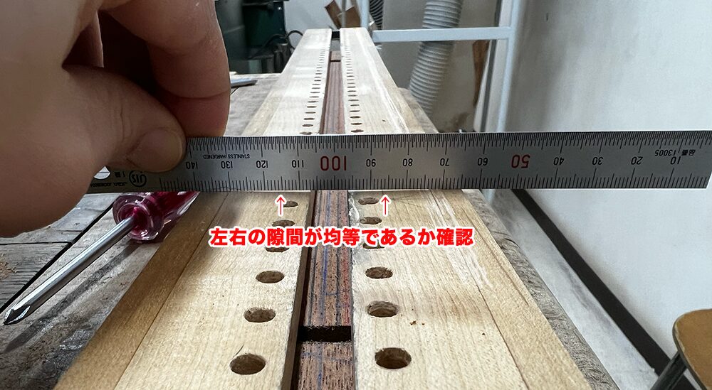 7弦ギターのネック材とトラスロッド溝掘りの治具が平行に設置されているかスケールで確認